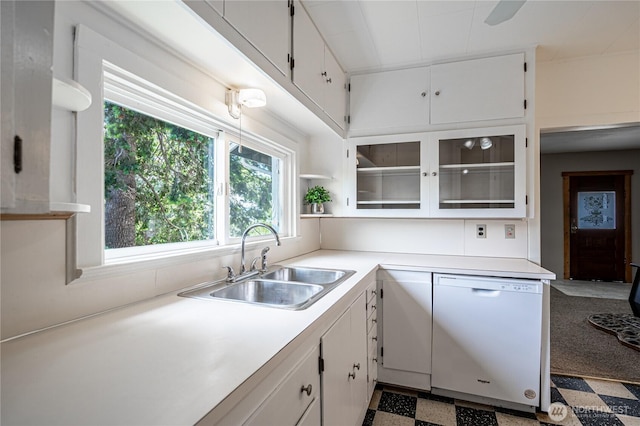 595 Division St, Manson, WA 98831 - kitchen with white dishwasher, a sink, tile patterned floors, and white cabinetry