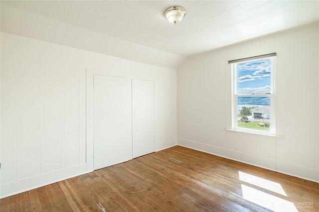 595 Division St, Manson, WA 98831 - additional living space featuring wood-type flooring, lofted ceiling, a decorative wall, and baseboards