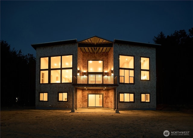 27208 J Ln, Ocean Park, WA 98640 - back of house at twilight with a balcony, a patio, and brick siding