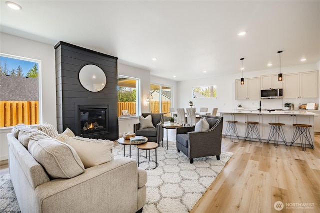 2818 Hazelwood Dr, Blaine, WA 98230 - living area featuring light wood finished floors, healthy amount of natural light, a large fireplace, and recessed lighting