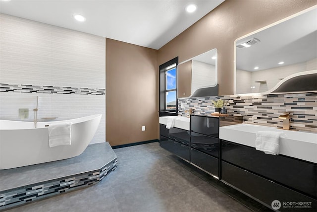 5496 Grandview Rd, Blaine, WA 98230 - full bathroom with double vanity, tasteful backsplash, a freestanding bath, recessed lighting, and concrete flooring