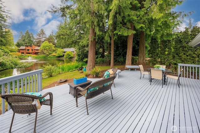 11423 NE 104th St, Kirkland, WA 98033 - wooden terrace featuring a water view, outdoor dining space, and view of scattered trees