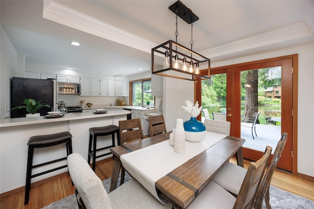 11423 NE 104th St, Kirkland, WA 98033 - dining space with crown molding, a raised ceiling, light wood-type flooring, recessed lighting, and french doors