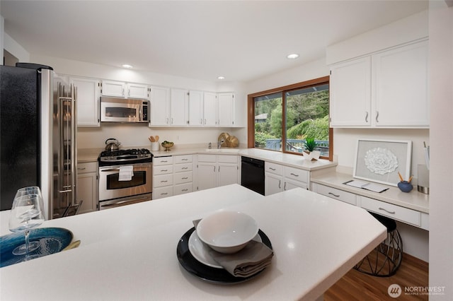 11423 NE 104th St, Kirkland, WA 98033 - kitchen featuring stainless steel appliances, wood finished floors, a peninsula, light countertops, and recessed lighting