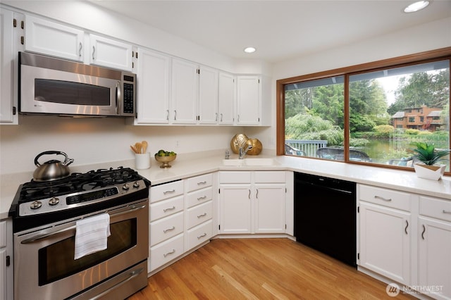 11423 NE 104th St, Kirkland, WA 98033 - kitchen featuring stainless steel appliances, light countertops, light wood-style floors, white cabinetry, and recessed lighting