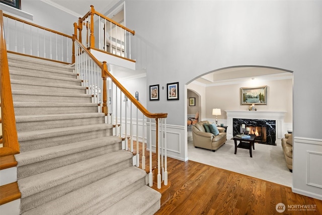 3924 Montgomery Ct, Mount Vernon, WA 98274 - stairs featuring arched walkways, crown molding, a high ceiling, wood finished floors, and a fireplace