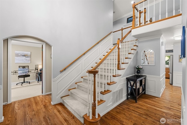 3924 Montgomery Ct, Mount Vernon, WA 98274 - stairway featuring wood finished floors, ornamental molding, arched walkways, and wainscoting
