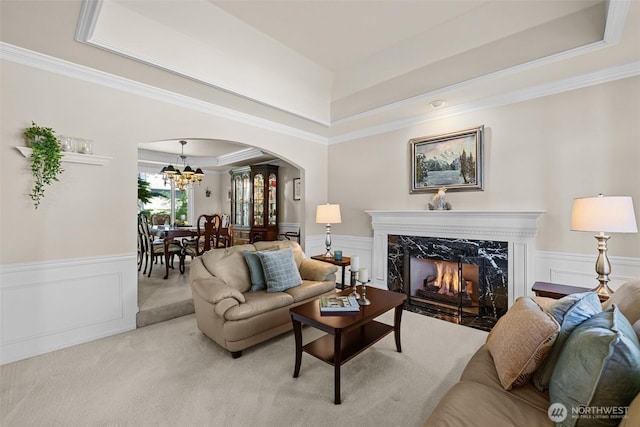 3924 Montgomery Ct, Mount Vernon, WA 98274 - living area featuring a raised ceiling, arched walkways, a chandelier, wainscoting, and ornamental molding