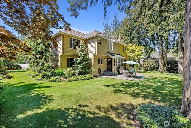 3924 Montgomery Ct, Mount Vernon, WA 98274 - back of property with a patio area, a lawn, and a chimney