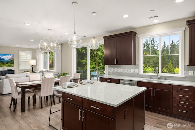 kitchen featuring a sink, open floor plan, healthy amount of natural light, decorative backsplash, and recessed lighting