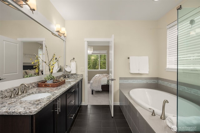 full bathroom featuring tile patterned flooring, a garden tub, double vanity, baseboards, and ensuite bath