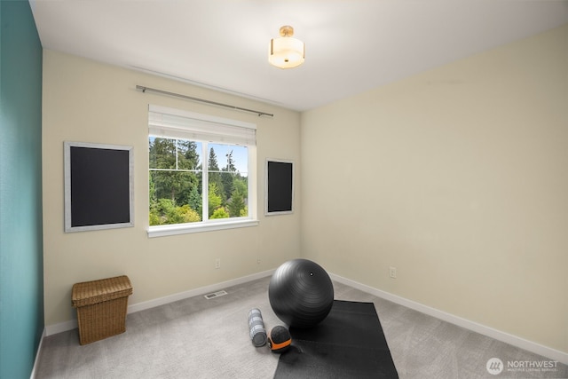 workout area with light colored carpet and baseboards