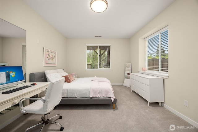 bedroom with light carpet and baseboards