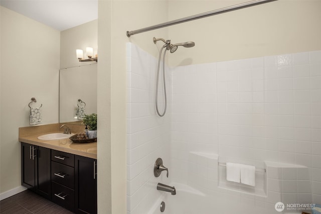 bathroom featuring bathing tub / shower combination, vanity, and baseboards