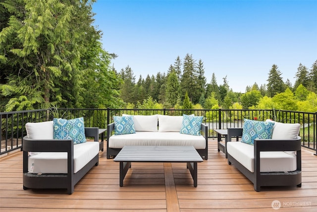 deck with an outdoor hangout area and a wooded view