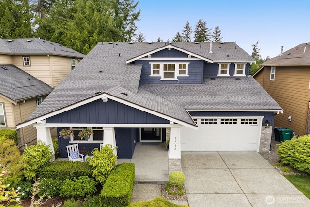 craftsman house featuring a shingled roof, driveway, board and batten siding, a garage, and covered porch