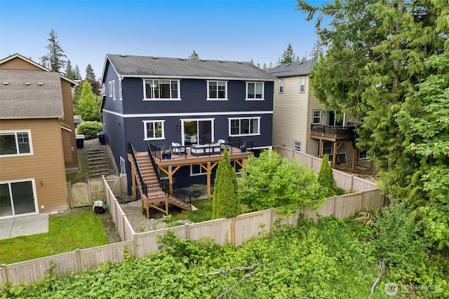 rear view of property with stairs, a deck, and a fenced backyard