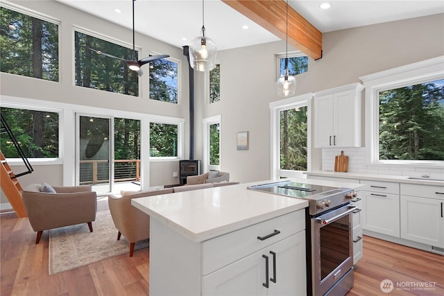 23 Byron Ln, Leavenworth, WA 98826 - kitchen with high end stainless steel range, light wood-type flooring, healthy amount of natural light, a towering ceiling, and beamed ceiling