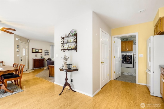 1811 Hundley Rd, Cle Elum, WA 98922 - kitchen with freestanding refrigerator, independent washer and dryer, light wood finished floors, a ceiling fan, and brown cabinetry