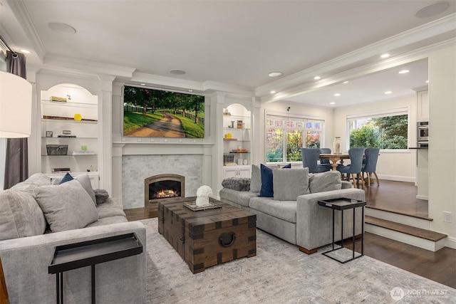 9209 SE 57th St, Mercer Island, WA 98040 - living room featuring ornamental molding, wood finished floors, a large fireplace, baseboards, and built in features