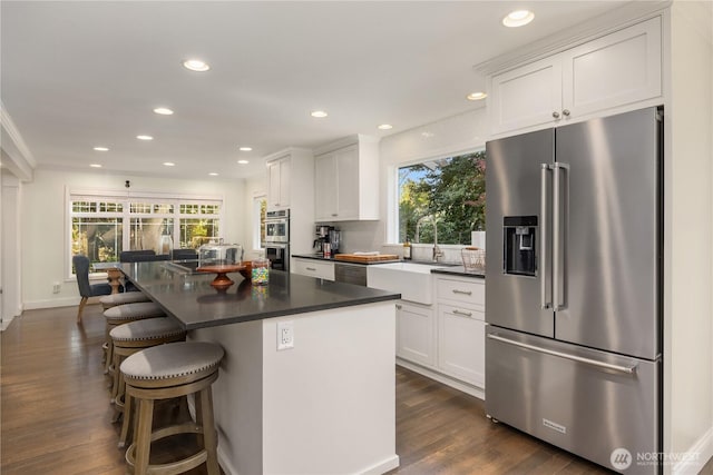9209 SE 57th St, Mercer Island, WA 98040 - kitchen featuring stainless steel appliances, a sink, dark countertops, recessed lighting, and white cabinetry