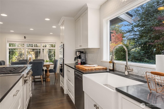 9209 SE 57th St, Mercer Island, WA 98040 - kitchen featuring stainless steel appliances, a sink, dark countertops, decorative backsplash, and recessed lighting