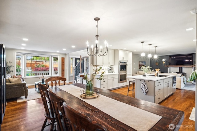 4279 H Street Rd, Blaine, WA 98230 - dining space featuring a chandelier, wood finished floors, recessed lighting, and stairway