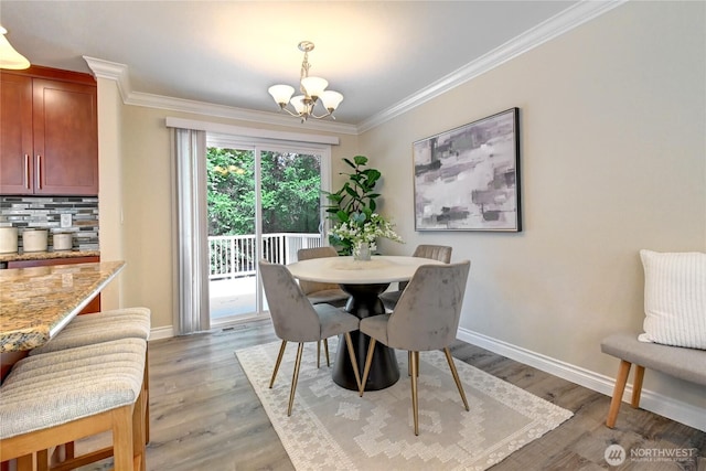 26309 187th Ct SE, Covington, WA 98042 - dining area with a chandelier, baseboards, ornamental molding, and light wood finished floors