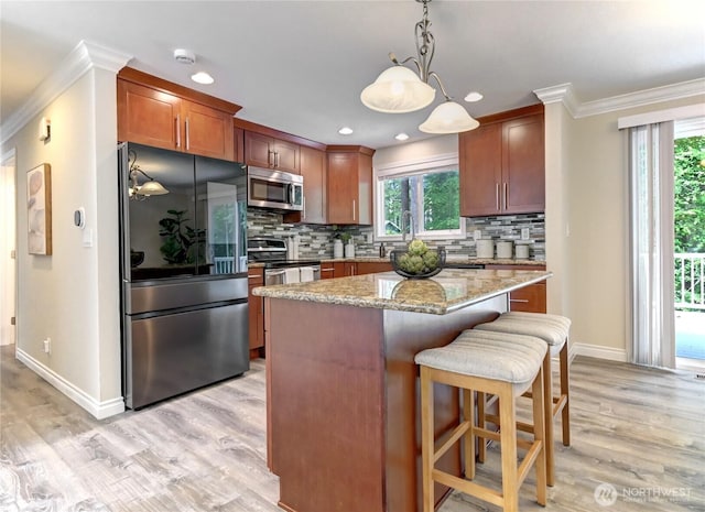 26309 187th Ct SE, Covington, WA 98042 - kitchen featuring stainless steel appliances, ornamental molding, baseboards, light wood-type flooring, and tasteful backsplash