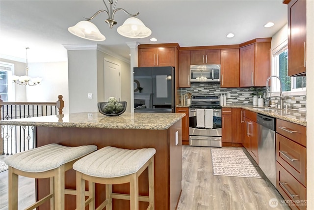26309 187th Ct SE, Covington, WA 98042 - kitchen with appliances with stainless steel finishes, a chandelier, a sink, crown molding, and backsplash