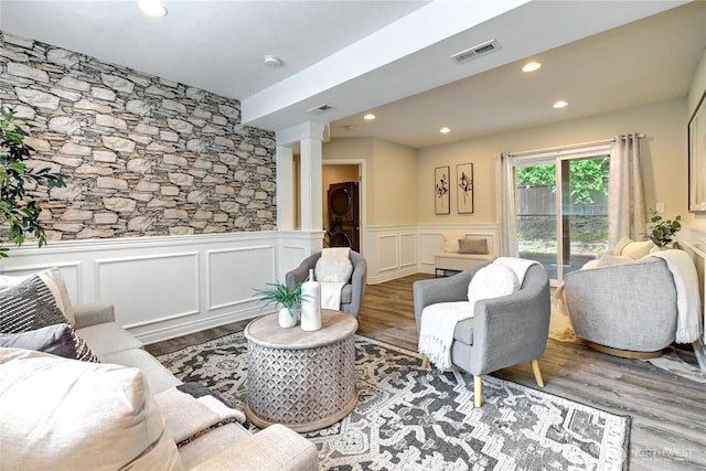 26309 187th Ct SE, Covington, WA 98042 - living room featuring stacked washing machine and dryer, ornate columns, wainscoting, wood finished floors, and recessed lighting