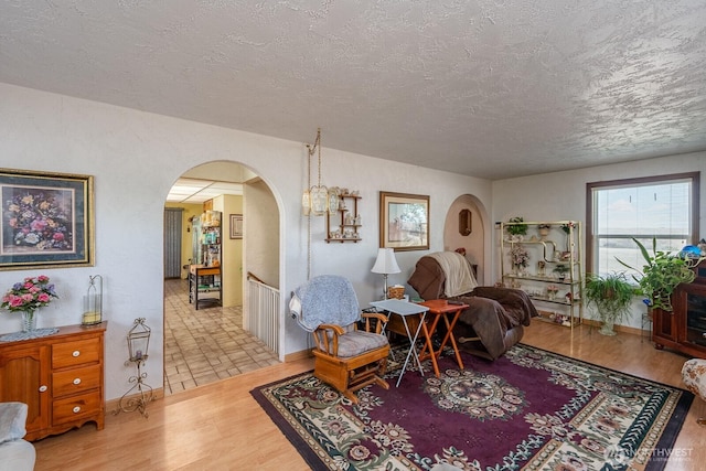 517 Marginal Way, Quincy, WA 98848 - living room featuring arched walkways, a textured ceiling, wood finished floors, and baseboards