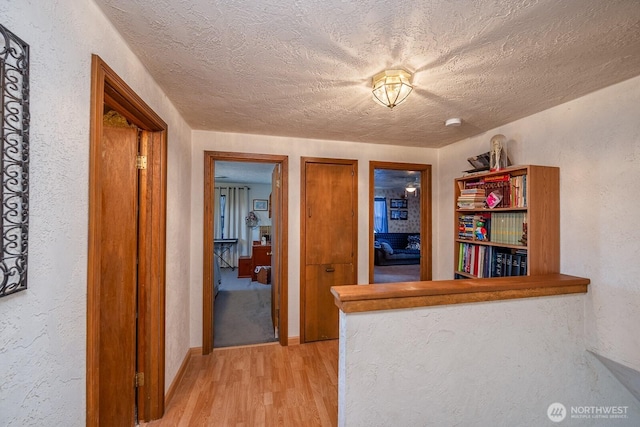517 Marginal Way, Quincy, WA 98848 - hall featuring light wood-type flooring, a textured ceiling, a textured wall, and baseboards