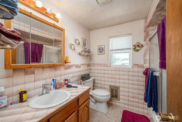 517 Marginal Way, Quincy, WA 98848 - full bathroom with a stall shower, tile patterned flooring, vanity, toilet, and tile walls