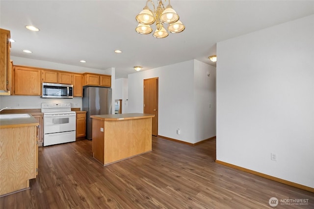 1114 Sinclair Way Unit 63, Burlington, WA 98233 - kitchen featuring appliances with stainless steel finishes, a center island, dark wood-type flooring, baseboards, and a sink