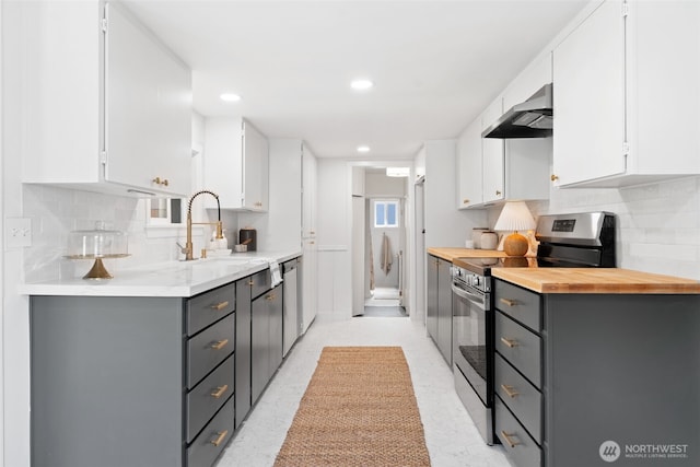 6709 E I St, Tacoma, WA 98404 - kitchen with appliances with stainless steel finishes, gray cabinets, extractor fan, white cabinetry, and backsplash