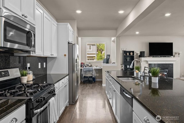 8657 Atlas Ave NE, Lacey, WA 98516 - kitchen with appliances with stainless steel finishes, a sink, white cabinets, wood finished floors, and dark stone counters