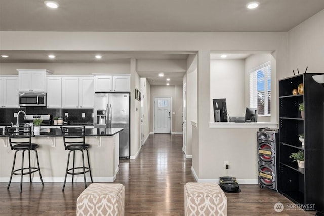 8657 Atlas Ave NE, Lacey, WA 98516 - kitchen featuring stainless steel appliances, a breakfast bar area, dark wood finished floors, recessed lighting, and white cabinets