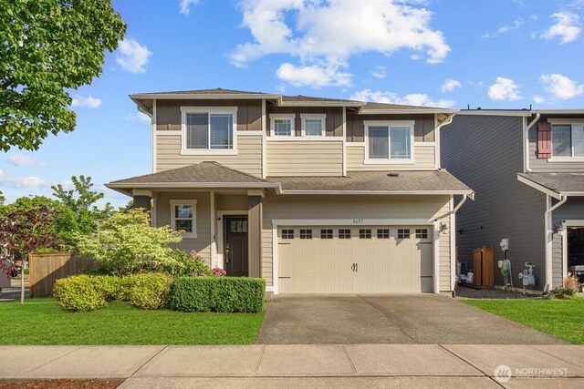 8657 Atlas Ave NE, Lacey, WA 98516 - view of front of home with a garage, concrete driveway, board and batten siding, and a shingled roof