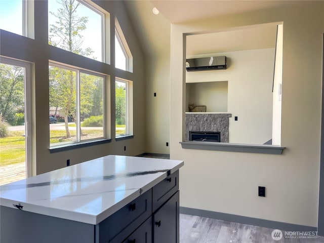 322 Fathom St NE, Ocean Shores, WA 98569 - kitchen featuring a wall unit AC, plenty of natural light, a fireplace, and light countertops