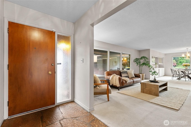 907 Baker St, Bellingham, WA 98225 - foyer entrance featuring carpet flooring, a textured ceiling, and a chandelier