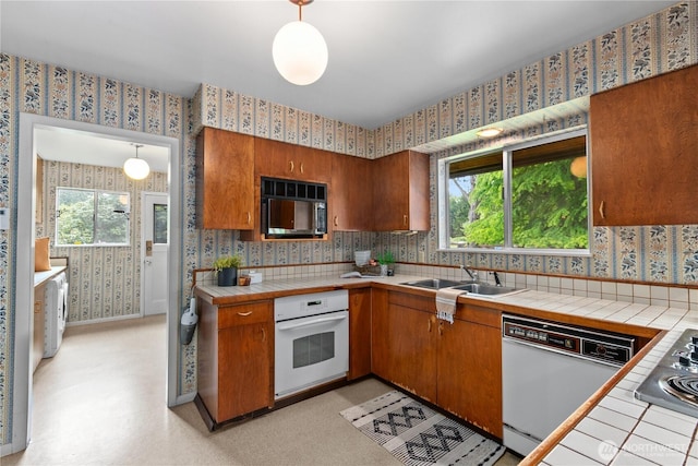 907 Baker St, Bellingham, WA 98225 - kitchen featuring wallpapered walls, white appliances, a sink, tile countertops, and brown cabinetry