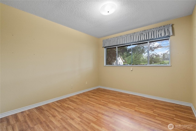 907 Baker St, Bellingham, WA 98225 - empty room featuring light wood-style flooring, baseboards, and a textured ceiling