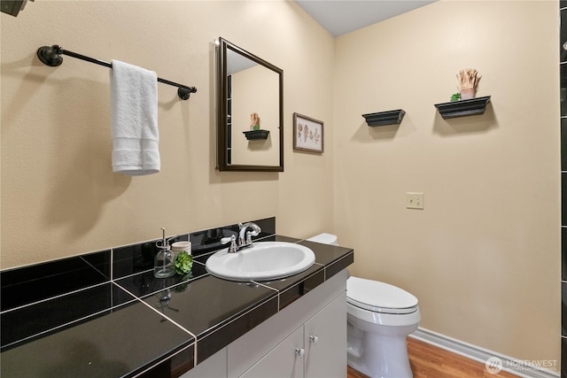 907 Baker St, Bellingham, WA 98225 - bathroom featuring wood finished floors, toilet, vanity, and baseboards