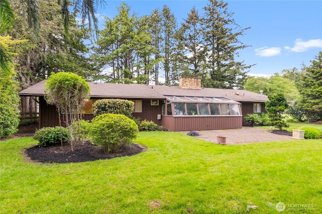 907 Baker St, Bellingham, WA 98225 - back of house featuring a sunroom, a yard, a patio area, and a chimney