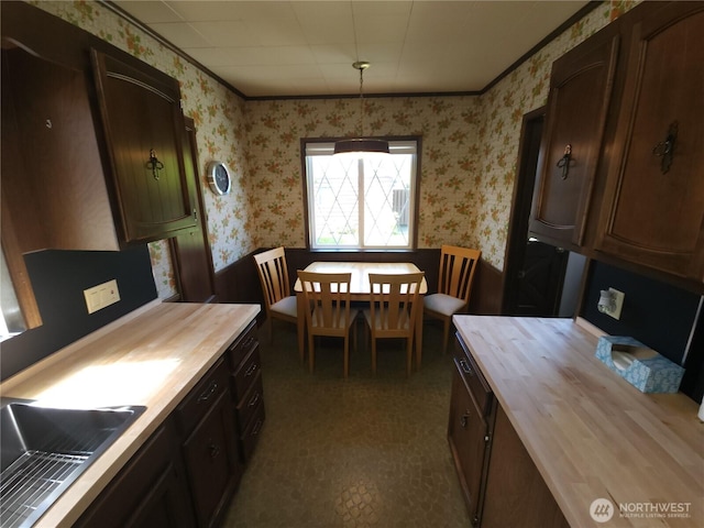 116 W 4th, Port Angeles, WA 98362 - kitchen featuring wood counters, wallpapered walls, wainscoting, and dark brown cabinetry