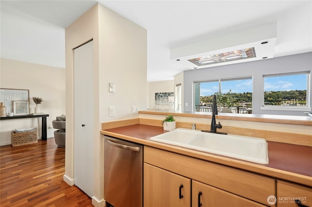701 Galer St Unit 808, Seattle, WA 98109 - kitchen with stainless steel dishwasher, a sink, wood finished floors, light brown cabinets, and light countertops