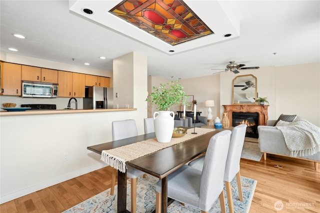 701 Galer St Unit 808, Seattle, WA 98109 - dining room featuring light wood-style floors, recessed lighting, ceiling fan, a fireplace, and baseboards