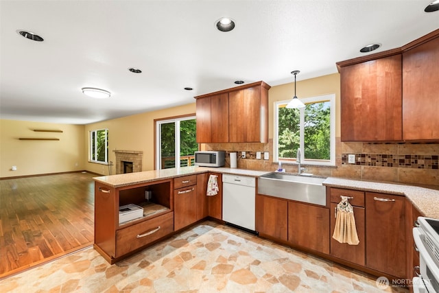 4528 SW 316th Pl, Federal Way, WA 98023 - kitchen with white appliances, a sink, brown cabinets, a peninsula, and decorative backsplash