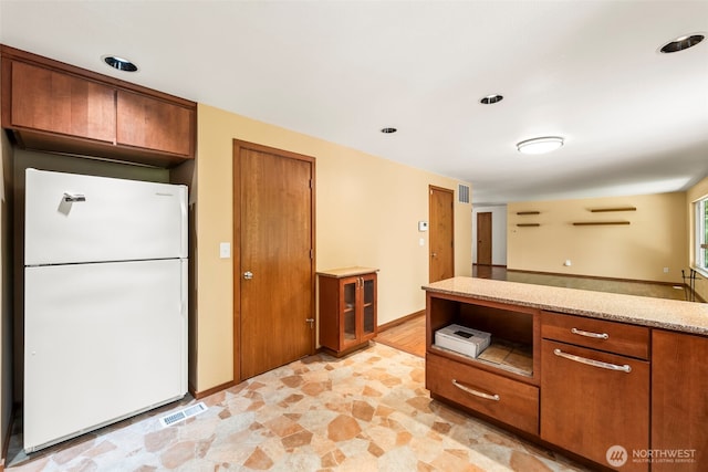 4528 SW 316th Pl, Federal Way, WA 98023 - kitchen featuring freestanding refrigerator, brown cabinetry, light stone countertops, and light stone finish flooring